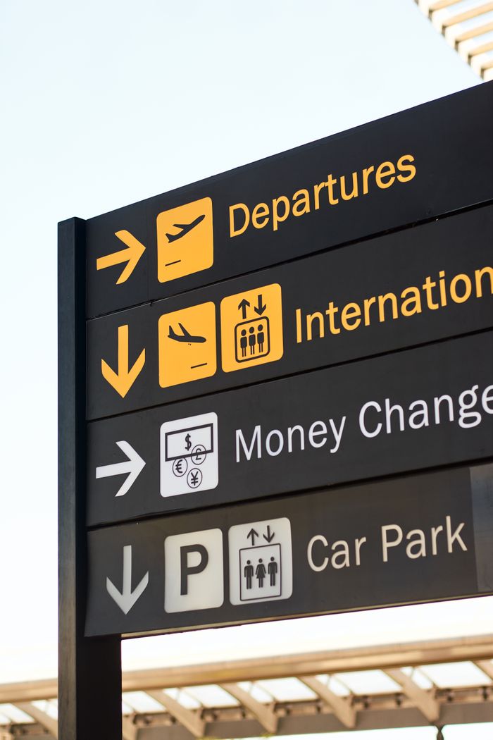 services-04 Close-up of airport direction signs for departures, international, money change, and car park.