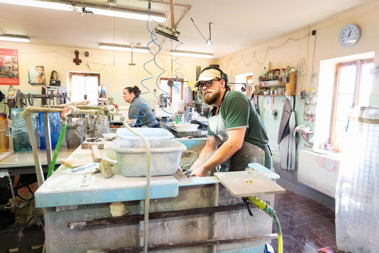 Craftsmen working in a glass workshop in Cvikov, showcasing traditional techniques.